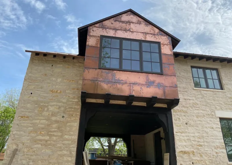 Copper metal panel facade on a stone building for Skylight Installation in East Moline